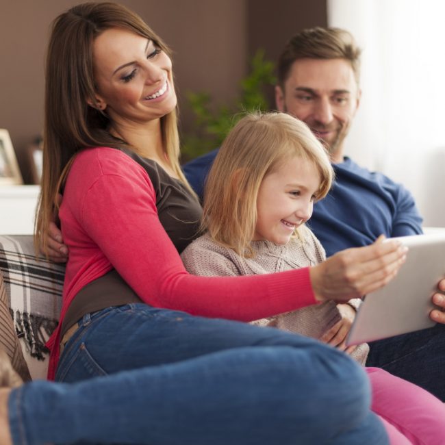 Happy family using digital tablet at home