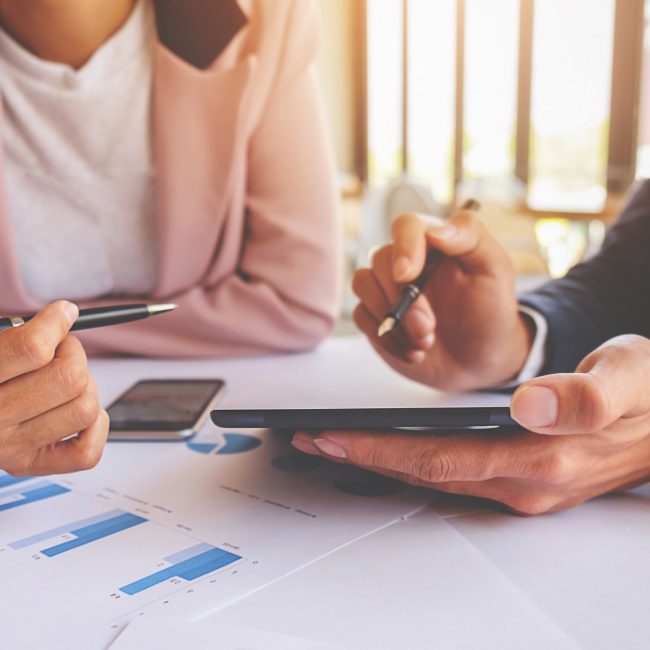 Business concept. Business people discussing the charts and graphs showing the results of their successful teamwork. Selective focus.